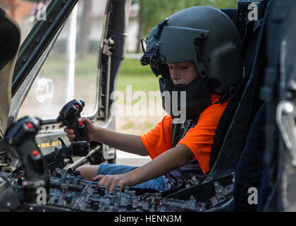 Un enfant fait semblant d'être un pilote à l'intérieur un UH-60 Black Hawk lors de la 2e Bataillon letton 12e anniversaire de la célébration en Adazi, la Lettonie, le 24 juillet. Les soldats américains à partir de la 12e Brigade d'aviation de combat et 173e Brigade aéroportée sont en Lettonie pour démontrer son engagement à l'OTAN et d'obligations pour accroître l'interopérabilité avec les forces alliées dans le cadre de l'opération Atlantic résoudre. (U.S. Photo de l'armée par le Sgt. Michael T. Crawford/libérés) lettone, les soldats américains célèbrent l'histoire militaire locale 140724-A-JH560-002 Banque D'Images