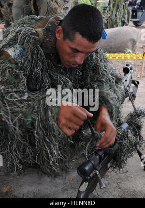 Membre de l'équipe de tireurs d'opérations spéciales guatémaltèques ajoute un couvercle pour camoufler son fusil pour tireur d'événement de la manette Fuerzas Comando 2014 au Fort Tolemaida, Colombie, le 26 juillet. Des équipes de 17 nations à travers l'hémisphère occidental sont en concurrence de juillet 23-31, pas seulement à déterminer un gagnant, mais aussi d'améliorer leur formation et de renforcer la coopération régionale et multinationale, la confiance mutuelle, l'état de préparation et l'interopérabilité des forces spéciales dans la région. Sud du commandement des opérations spéciales des États-Unis sert d'agent d'exécution de l'exercice. Fuerzas Comando a été créé en Banque D'Images