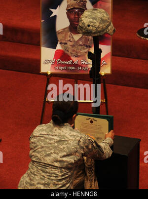 Le capitaine Angelica Laboone, commandant de la Compagnie C, Transition guerrier bataillon, Fort Sam Houston, Texas, place un Army Commendation Medal sur cps. Donnell Hamilton's pendant la bataille Hamilton's memorial service à Fort Sam Houston's main post office le 31 juillet. Hamilton a été attribué à et déployés avec la société D, 1er Bataillon, 5e régiment de cavalerie, 2e Brigade Combat Team, 1re Division de cavalerie, de Fort Hood, au Texas, en tant qu'équipage blindé avant d'une maladie lui a envoyé à la FS. (U.S. Photo de l'armée par le Sgt. Quentin Johnson, 2e parution PAO/BCT) disparu, mais pas oublié, les troupes se rappellent leur soldat Cav Banque D'Images