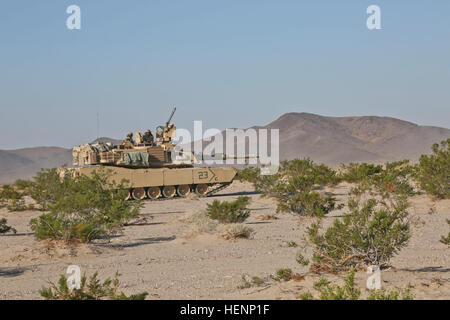 Les soldats de l'armée américaine de la Compagnie Alpha, 3e Bataillon, 69e régiment de blindés, 1st Armored Brigade Combat Team, 3e Division d'infanterie, d'une numérisation dans le périmètre d'un M1 Abrams tank lors d'une action décisive 14-09 Rotation au Centre National d'entraînement à Fort Irwin, en Californie, 9 août, 2014. L'action décisive de l'environnement de formation ont été développés pour les rotations créer un scénario de formation commune pour l'ensemble de l'armée. (U.S. Photo de l'armée par la CPS. Randis Monroe/libéré) Abrams manoeuvre 140809-A-XB890-001 Banque D'Images