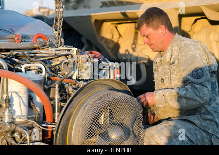 Le Sgt. 1re classe Paul Hussey, le mécanicien chef section de réservoir pour l'entreprise F, 145e Bataillon de soutien de la Brigade lourde, 116e Brigade Combat Team, travaille sur le moteur d'un Abrams M1A2 Forfait amélioré du système (SEP) Réservoir à l'appui d'un réservoir de tir réel au cours de la gamme de formation annuel de l'unité au Centre de formation du verger près de Boise, Idaho, le 21 août. En tout, plus de 500 soldats de la Garde nationale de l'Armée de l'Oregon formés pendant deux semaines à OTC, où les commandants de préparation d'une évaluation unique de chaque unité. (U.S. Photo par le Sgt 1re armée. Kevin Hartman, Mobile 115 Détachement des affaires publiques, de l'Armée de l'Oregon Nati Banque D'Images