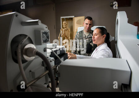 Un assistant de physiothérapie au laboratoire national d'Argonne explique les composants de la machine à rayons X à un soldat de l'armée américaine du 863e bataillon du génie pour promouvoir l'engagement STIM parmi les soldats citoyens à Darien, Illinois, le 26 août 2014. Banque D'Images
