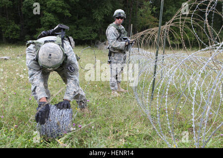 Les soldats de la Compagnie Alpha, 173e Bataillon des troupes spéciales de la Brigade, 173e Brigade aéroportée construire un barbelé obstacle pendant l'exercice de formation à la jonction de Sabre 2014 Centre de préparation interarmées multinationale dans Hohenfels, Allemagne, le 29 août 2014. Jonction 2014 Sabre américain prépare, alliés de l'OTAN, et la sécurité européenne partenaires de mener des opérations terrestres unifiée grâce à la combinaison simultanée d'offensive, défensive, et les opérations de stabilisation adaptés à la mission et de l'environnement. Plus d'informations sur la sortie de Sabre 2014 peuvent être trouvés à http://www.eur.army.mil/SaberJun Banque D'Images