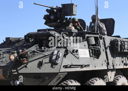 Des soldats américains affectés à la 4e Bataillon, 23e Régiment d'infanterie, donner des instructions au Japon d auto-défense au sol sur les soldats pendant le fonctionnement de véhicules Stryker Rising Thunder 2014 à Yakima, dans l'état de Centre de formation, le 6 septembre 2014. Rising Thunder est un U.S. Army-ont accueilli l'exercice conçu pour renforcer l'interopérabilité entre le 1 Corps, la 7e Division d'infanterie et de l'Autodéfense de masse au Japon. (U.S. Photo de l'armée par le sergent. Mark Miranda/libéré) des soldats américains affectés à la 4e Bataillon, 23e Régiment d'infanterie, donner des instructions au Japon d auto-défense au sol environ soldats Stryk Banque D'Images