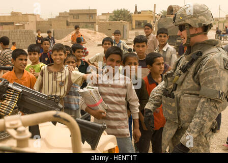 La FPC. Michael McNeil, de la Police militaire 511e Co., partage une blague avec les enfants iraquiens après une distribution de nourriture dans le Zuwerijat mission district de Al Kut, l'Iraq, le 30 avril. (U.S. Photo de l'armée/Sgt. Daniel T. à l'Ouest) de l'ISF, les forces de la coalition à distribuer de la nourriture, des jouets 86547 Banque D'Images