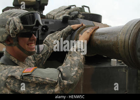 Le Cpl. William Defreest, un réservoir gunner dans l'entreprise C, 2e Bataillon, 12e Régiment de cavalerie, 1 Brigade Combat Team, 1re Division de cavalerie les graisses jusqu'à la cuve principale pendant la pré-feu vérifie à Grafenwoehr Domaine de formation, l'Allemagne, le 1er octobre. Greasin' up le tube du canon 141001-A-SJ786-023 Banque D'Images