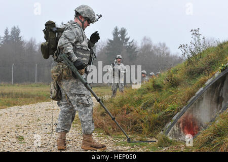 Des soldats américains avec la 702e Explosive Ordnance Disposal Company recherche des dispositifs explosifs possibles pendant le 1er Escadron, 91e Régiment de cavalerie, l'assaut de la 173e Brigade aéroportée dans un environnement urbain formation à la 7e armée multinationale interarmées du Commandement de l'aire d'entraînement Grafenwoehr, Allemagne, le 20 novembre, 2014. La formation fait partie d'un exercice d'une semaine organisé par l'escadron, conçu pour enseigner aux dirigeants de la brigade, ainsi que les alliés du 43e bataillon aéroporté tchèque de l'armée allemande, l'École de l'OTAN, du détachement et de l'Estonie Bataillon Scouts la planification et l'exécution de temps-sensit Banque D'Images