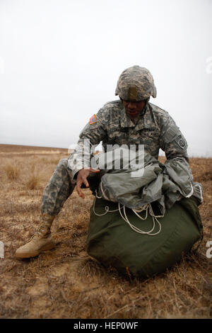 Pv2 Alex Dickerson, de l'Administration centrale et de l'Administration Centrale du 1er Bataillon, 319e Batterie d'artillerie sur le terrain, packs son parachute après avoir complété un levé lors de la 17e édition de Randy Oler Opération Memorial Toy Drop, organisé par l'armée américaine et des affaires civiles de la commande d'opérations psychologiques (Airborne), le 6 décembre 2014 sur la zone de la Sicile à Fort Bragg, Caroline du Nord. Jouet opération Drop est la plus grande opération aéroportée combiné avec six pays partenaire alliées participant parachutistes et permet aux soldats la possibilité d'aider les enfants dans le besoin tout au long de la communauté locale de recevoir des jouets pour le Banque D'Images