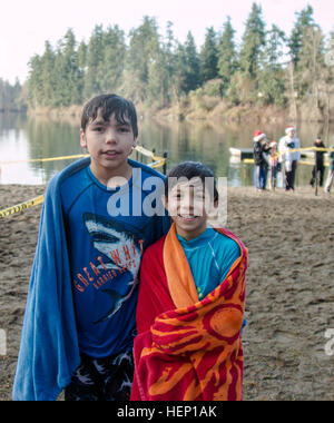 Ari et Eli Vitor, âgés de 12 et 8, vous réchauffer après une baignade dans l'eau froide pendant la première Joint Base Lewis-McChord Aller polaires et trempette 5k et 2k fun run ou à pied à Shoreline Park, Joint Base Lewis-McChord, qui a eu lieu le 13 décembre 2014. Plus de 200 adultes a terminé la 5k, près de 50 enfants a terminé la 2k et beaucoup ont bravé le froid de l'eau Lac américain pour compléter la partie dip après la course. Ils ont eu plusieurs prix de présence donnés durant la trempette dans le lac américain part avec deux grands prix, une tablette de Dell et un certificat-cadeau au Great Wolf Lodge. (U.S. Photo de l'armée par le sergent. Mica Banque D'Images