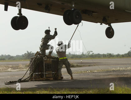 Le Sgt. Anton Novosselov et la FPC. Nathan Watson avec 372e de transfert de cargaison à l'intérieur des terres, de l'entreprise 129e Bataillon de soutien au maintien en puissance de combat, la 101e Brigade de soutien, Groupe de travail Lifeliner, à partir de Fort Campbell, Ky., attendre un hélicoptère Chinook Cargo (47) de les approcher à charge un ensemble de carburant d'urgence à un laboratoire médical mobile à Greenville, Libéria, dans le cadre de l'opération Assistance aux 21 décembre, 2014. Le 2e Bataillon de l'aviation d'appui général, 501e Régiment d'aviation, 1st Armored Division Aviation Brigade, de Fort Bliss, Texas, à condition que l'appui de l'aviation, Aérodrome Roberts Monrovia Banque D'Images