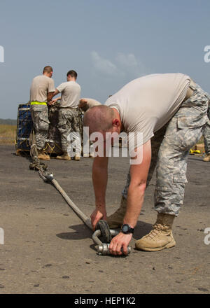 Le Sgt. Anton Novosselov avec la 372e compagnie de transfert des cargaisons intérieures, 129e Bataillon de soutien au maintien en puissance de combat, la 101e Brigade de soutien, Groupe de travail Lifeliner, à partir de Fort Campbell, Kentucky, inspecte l'élingue comme apex jambe son équipe prépare une élingue de charger le paquet d'urgence de carburant pour un laboratoire médical mobile situé à Greenville, au Libéria, dans le cadre de l'opération Assistance aux 21 décembre, 2014. L'opération United Assistance est une opération du Ministère de la Défense au Libéria pour fournir la logistique, de la formation et du soutien technique à l'Agence des États-Unis pour le développement international, a dirigé les efforts visant à contenir le virus Ebola vir Banque D'Images