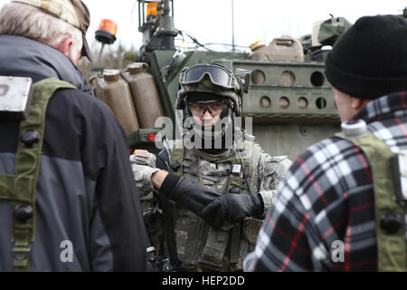 Un soldat américain de Némésis Troop, 4e Escadron, 2e régiment de cavalerie donne la direction pour le jeu de rôle des civils lors d'un écran de peloton pendant l'exercice Allied esprit je au Centre de préparation interarmées multinationale à Hohenfels, Allemagne, le 15 janvier 2015. L'esprit des alliés de l'exercice comprend plus de 1 600 participants du Canada, Hongrie, Pays-Bas, Royaume-Uni, et l'esprit des alliés des États-Unis est l'exercice de l'interopérabilité tactique et les tests des communications sécurisées au sein des membres de l'alliance. (U.S. Photo de l'armée par la FPC. Lloyd Villanueva/libérés) Allied esprit je 150115-A-GT858-007 Banque D'Images