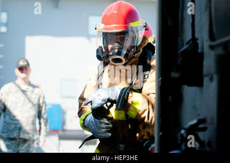 La CPS. Daniel Huntley, de Clayton, Californie, affecté à la 97e compagnie de transport (bateau lourd), 10e bataillon de transport, 7e brigade expéditionnaire (transport), s'apprête à enfreindre une zone de confinement refroidi pendant une simulation d'incendie à bord du bateau de débarquement à Corinthe de l'utilitaire de la base navale de Koweït, le 24 janvier. (U.S. Photos de l'armée par le sergent. Gene Arnold, Mobile 7e Détachement des affaires publiques) effectue des motomarines exercice incendie 150124-A-MX893-005 Banque D'Images