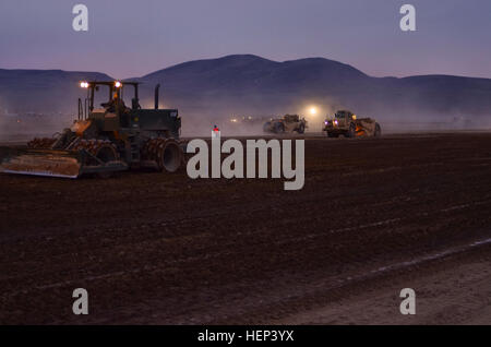 Les soldats de la 411e compagnie du génie, Iowa City, travailler à travers la construction d'une piste d'atterrissage de nuit au Fort Irwin Centre National de Formation en Californie. Le projet, dirigé par le 389e bataillon du génie, fournira des NTC avec deux pistes, 8 000 pieds carrés et un tablier de 1 000 pieds carrés qui permettra à C-130 et C-17 à la terre sur Irwin. (Photo par le Sgt. 1re classe Valerie Resciniti) Fort Irwin atterrissage 150218-A-RE257-003 Banque D'Images