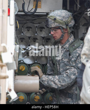 Un soldat de l'armée américaine de la Compagnie Alpha, 3e Bataillon, 82e Régiment d'artillerie, 2e Brigade Combat Team, 1re Division de cavalerie charge 155mm cannon arrondit dans un M109A6 Paladin au cours d'une action décisive 15-05 Rotation au Centre National d'entraînement, Fort Irwin, en Californie, le 22 février 2015. L'action décisive de l'environnement de formation a été développé pour créer un scénario de formation commune pour l'ensemble de l'armée. (U.S. Photo de l'armée par le Sgt. Richard W. Jones Jr./soldats libérés) charger des munitions avant d'attaquer les forces 150222 enermy-QU-A939-030 Banque D'Images