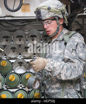 Un soldat de l'armée américaine de la Compagnie Alpha, 3e Bataillon, 82e Régiment d'artillerie, 2e Brigade Combat Team, 1re Division de cavalerie charge 155mm cannon arrondit dans un M109A6 Paladin au cours d'une action décisive 15-05 Rotation au Centre National d'entraînement, Fort Irwin, en Californie, le 22 février 2015. L'action décisive de l'environnement de formation a été développé pour créer un scénario de formation commune pour l'ensemble de l'armée. (U.S. Photo de l'armée par le Sgt. Richard W. Jones Jr./soldats libérés) charger des munitions avant d'attaquer les forces 150222 enermy-QU-A939-035 Banque D'Images