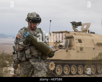 Un soldat de l'armée américaine de la Compagnie Alpha, 3e Bataillon, 82e Régiment d'artillerie, 2e Brigade Combat Team, 1re Division de cavalerie charge 155mm cannon arrondit dans un M109A6 Paladin au cours d'une action décisive 15-05 Rotation au Centre National d'entraînement, Fort Irwin, en Californie, le 22 février 2015. L'action décisive de l'environnement de formation a été développé pour créer un scénario de formation commune pour l'ensemble de l'armée. (U.S. Photo de l'armée par le Sgt. Richard W. Jones Jr./soldats libérés) charger des munitions avant d'attaquer les forces 150222 enermy-QU-A939-049 Banque D'Images