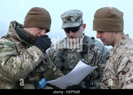 Le capitaine de l'armée américaine Kenneth O'Reilly, centre, de l'équipe multinationale interarmées Timberwolves, Centre de préparation (JMRC) ainsi qu'un soldat géorgien, à gauche, de la Compagnie Alpha, 43e Bataillon d'infanterie mécanisée, 4e Brigade d'infanterie mécanisée, et un U.S. Marine Corps des Marines américains de la coopération en matière de sécurité des opérations courantes du groupe de discuter tout en effectuant une opération de bouclage et de recherche au cours d'un scénario de formation exercice de répétition de mission (MRE) à l'armée américaine en JMRC Hohenfels, Allemagne, 26 février 2015. Les forces armées géorgiennes et MCSCG mènent la MRE à partir de 2 février au 3 mars 2015, dans le cadre de la déployer géorgienne Banque D'Images