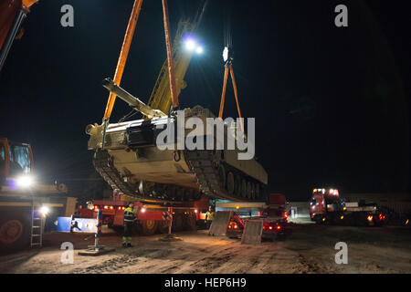 Les grutiers letton décharger une M1 Abrams tank de 2/7 bataillon d'infanterie, 1ère Brigade, 3e Division d'infanterie, à Adazi Domaine de formation, la Lettonie, le 10 mars 2015. 3ème Division d'infanterie chars arrivent en Lettonie 150310-A-KG432-289 Banque D'Images