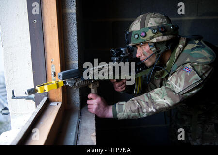 Un cadet de l'Académie Royale Militaire de Sandhurst cherche des ennemis au cours de l'évaluation finale et la validation de la formation au Centre de préparation interarmées multinationale à Hohenfels, Allemagne, le 20 mars 2015. Le but de l'exercice de certification est de former et d'évaluer des cadets à la prise de décisions, la planification, l'expertise métier sur le terrain, et des opérations dans un environnement tactique afin de préparer les élèves-officiers pour la mise en service dans l'armée britannique. (U.S. Photo de l'armée par le Sgt. 1re classe Caleb Barrieau) l'Académie Royale Militaire de train à JMRC 150320-A-BM953-960 Banque D'Images