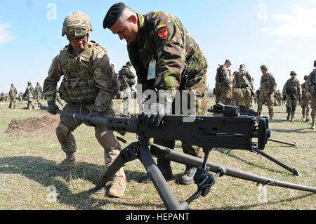 Pvt. Jongmin chanson, un fantassin attribué à Ghost Troop, 2e Escadron, 2e régiment de cavalerie, montre un soldat Roumain Roumain affecté à l'Armée de terre, comment retirer le canon d'un M2 mitrailleuse de calibre .50 lors d'une exposition statique fournie par son unité après avoir participé à la cérémonie d'ouverture de printemps 2015 du vent à Galati, Roumanie Zone de formation, le 16 avril 2015. Le vent Printemps 2015 exercice vise à maintenir et accroître l'interopérabilité entre les alliés de l'OTAN. (U.S. Photo de l'armée par le Sgt. William A. Tanner/relâché), paras US Forces terrestres roumaines et des soldats britanniques particip Banque D'Images