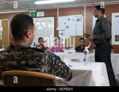 Un officier de police irakien l'écoute d'un autre agent au cours d'un bloc d'enseignement en classe au cours de l'Union européenne la mission intégrée "État de droit pour l'Iraq Formation des formateurs à la base d'opérations d'urgence à Bassorah, le 21 mars. Le cours lui-même a été conçu pour enseigner aux étudiants la formation différentes théories qui va les aider dans l'enseignement de leurs collègues policiers. Ue  % % % % % % % %E2 % % % % % % % %80 % % % % % % % %99s la mission intégrée "État de droit pour l'Iraq mène des 'Former les formateurs' course 384548 Banque D'Images