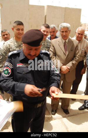 L'Irak le général de la police du district d'Abou Ghraib, chef de la police irakienne, coupe le ruban pour le nouveau centre de coordination conjoint à Abu Ghraib, à l'ouest de Bagdad, le 6 août 2008. Le CCM est composé de représentants de la police irakienne, l'armée irakienne, les membres de la communauté locale et des soldats du 1er Bataillon, 21e Régiment d'infanterie, 2e', 'vrilles Stryker Brigade Combat Team, 'Warrior', 25e Division d'infanterie, Division multinationale - Bagdad. L'ISF, ils collaborent avec vrilles pour maintenir des conditions de sécurité 107892 Banque D'Images