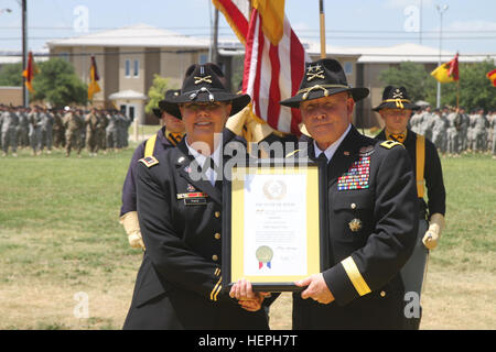 L'Adjudant chef Jeanne le rythme (à gauche), ancien chef de la Division de cavalerie Band, est présenté avec une plaque par le major-général Michael Factures, général commandant la division de cavalerie, sa mise en service, comme une rose jaune du Texas par Texas Gov. Greg Abbott au cours de sa retraite le 10 juillet sur Cooper Champ à Fort Hood, au Texas. Le rythme a pris sa retraite après plus de 43 ans dans l'armée. (U.S. Photo de l'armée par le sergent. Christopher Calvert, 1re Division de cavalerie/PAO) Parution le cavalier prend sa retraite après 43 ans de carrière 150710-A-RM324-070 Banque D'Images