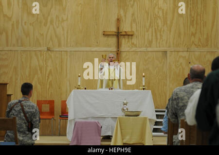 Le colonel Richard Spencer, un aumônier de la réserve de l'armée américaine et un évêque catholique des Etats-Unis à la Conférence des évêques de l'Archidiocèse pour le service militaire, consacre la Sainte Eucharistie et du vin pendant la messe le Jeudi Saint à la base d'opérations d'urgence à Bassorah, le 21 avril. United States Division-South est commandé et contrôlé par la 36e Division d'infanterie, Texas Army National Guard basée à Austin, Texas. L'Armée (photos par le Sgt. James K. Benjamin) des soldats américains sur S/N Bassora célèbrent la Semaine Sainte 110421-A-RT268-056 Banque D'Images