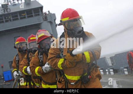 Des soldats de la réserve de l'armée américaine de la 481ème Compagnie de transport réagir à un exercice d'incendie sur l'utilitaire de débarquement au cours de la formation de Monterrey lors du Big Sur la rive de la logistique, de l'Ouest exerce à Alameda, Californie, 3 août 2015. Logistique Grand Ouest Over-The-Rive, est une plante annuelle, de la réserve de l'armée, multi-échelon exercice fonctionnel conçu pour les unités de transport et de soutien des commandes à perfectionner leurs compétences en logistique sur-le-port (lots) du 25 juillet au 7 août 2015. Plus de 750 soldats participent cette année. L'exercice est devenu un exercice à composantes multiples impliquant eleme Banque D'Images