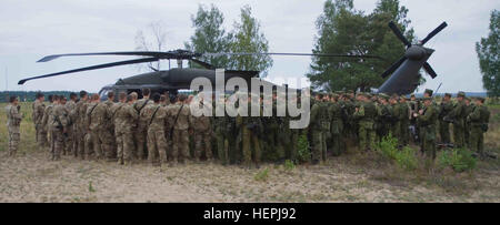 Les soldats de l'Armée américaine affecté à l'entreprise de chien, 1er Bataillon, 503e Régiment d'infanterie, 173ème Infantry Brigade Combat Team (Airborne), 4e Division d'infanterie et de forces terrestres lituanienne soldats affectés à la grande-duchesse Birutė Uhlan Bataillon (BUB), écouter un briefing initial de la part de l'équipage d'un Black Hawk UH-60M hélicoptère affecté à la Compagnie B, 43e Bataillon d'hélicoptères d'assaut, 3e régiment de cavalerie, 3e Division d'infanterie, au cours de l'exercice Furie du Uhlan tenue à l'Espace Formation Zlikaliskas Silvestras, Pabrade, Lituanie, 10 août 2015. Les alliés de l'OTAN ont travaillé ensemble dans le cadre d'exer Banque D'Images