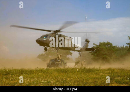 Des soldats américains affectés à la Compagnie B, 43e Bataillon d'hélicoptères d'assaut, 3e régiment de cavalerie, 3e Division d'infanterie, passez leur Black Hawk UH-60M hélicoptère au-dessus des soldats affectés à Dog Company, 1er Bataillon, 503e Régiment d'infanterie, 173ème Infantry Brigade Combat Team (Airborne), 4e Division d'infanterie et de forces terrestres lituanienne soldats affectés à la Grande Duchesse Birutė Uhlan Bataillon (BUB), après les équipes sur le terrain chargé de l'élingue avec succès une grande mobilité polyvalents pour les véhicules à roues (HMMWV) pendant la formation bilatérale appelée Uhlan Fury se tient actuellement à la génération Silvestras Banque D'Images