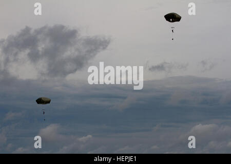 Les soldats de l'armée américaine, attribué à l'entreprise de chien, 1er Bataillon, 503e Régiment d'infanterie, 173ème Infantry Brigade Combat Team (Airborne), 4e Division d'infanterie, et de forces terrestres lituanienne soldats affectés à la 2e compagnie a, la grande-duchesse Birutė Uhlan Bataillon (BUB), parachuté d'hélicoptères Black Hawk UH-60M exploité par la Compagnie B, 43e Bataillon d'hélicoptères d'assaut, 3e régiment de cavalerie, 3e Division d'infanterie, après leurs sauts de temps a été repoussé de deux heures en raison du mauvais temps au cours de l'effort à la fureur de Uhlans Silvestras Général Zlikaliskas Domaine de formation, Pabrade, la Lituanie, le 13 août 2015. Banque D'Images