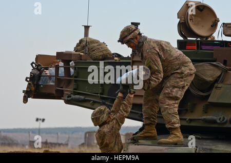 La FPC. Austin HinoJosa, un opérateur de transport à moteur de l'entreprise Delta, originaire de Leawood, Kansas, mains un 120mm ronde 2nd Lieutenant Hemaloto Tatafu Delta, un chef de section, de Kahuku, Hawaii, tant de 1st Armored Brigade Combat Team, attaché au 5e Escadron, 7e régiment de cavalerie, 3e Division d'infanterie, stationné à Fort Stewart, en Géorgie, au cours d'un exercice de formation sur le terrain dans le cadre de l'opération Atlantic résoudre à Novo Selo, Centre de formation, la Bulgarie, le 17 novembre 2015. (U.S. Photo de l'armée par le sergent. Steven M. Colvin/libérés) 1er ABCT boom apporte à la Bulgarie 151117-A-HO673-254 Banque D'Images