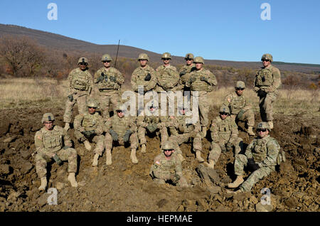 Les soldats du 1st Armored Brigade Combat Team, attaché au 5e Escadron, 7e régiment de cavalerie, 3e Division d'infanterie, en poste au Fort Stewart, Ga., posent pour une photo de groupe autour du cratère ils ont juste fait de 100 livres d'explosifs sur le terrain lors d'un exercice à l'appui de l'opération Atlantic résoudre à Novo Selo, Centre de formation, la Bulgarie, le 19 novembre 2015. Les frais des cratères sont utilisés afin de créer rapidement un obstacle dans un scénario tactique et à empêcher l'ennemi de la liberté de manœuvre. (U.S. Photo de l'armée par le sergent. Steven M. Colvin/libérés) 1er ABCT boom apporte à la Bulgarie 151119-A-HO673 Banque D'Images