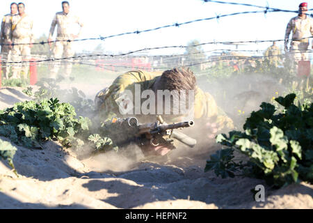 Un soldat australien avec Task Group montre comment Taji bas correctement ramper sous les barbelés lors d'une course d'obstacles au Camp Taji, l'Iraq, le 17 février 2016. Le parcours permet aux formateurs de voir les soldats irakiens' capacités physiques. Camp Taji est l'un des cinq Combined Joint Task Force - Fonctionnement résoudre inhérent à renforcer les capacités des partenaires endroits consacrés à la formation des forces de sécurité iraquiennes. (U.S. Photo de l'armée par le Sgt. Kalie Jones/libérés) bataillon de sécurité, Ninive Operations Command conduite parcours 160217-A-KH215-018 Banque D'Images