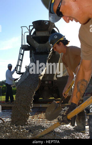 GUANTANAMO BAY, Cuba - Maître de 2e classe de la Marine Rachel Thompson et le Maître de 2e classe de la Marine Mario Perez pelle et propagation du béton frais comme il verse de la chute d'un camion de ciment. Thompson et Perez, tous deux travaillant avec les Seabees Naval Station Travaux publics Ministère d'auto-assistance, a travaillé pour construire un socle de ciment pour la fondation du nouveau centre Liberty Kay Tierra, un lieu où la Force opérationnelle Guantanamo Troopers peuvent se détendre et se divertir. Guantanamo la foi mène sûr, humain, juridique et transparent le soin et la garde de détenus des combattants ennemis, y compris ceux condamnés par la coopération militaire Banque D'Images