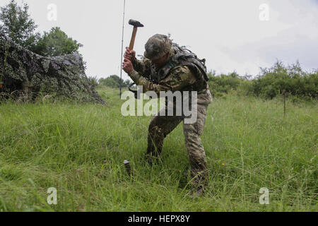 Un soldat britannique du 7e Régiment de parachutistes Royal Horse Artillery marteaux un jeu alors que l'assemblage d'un ensemble de communications au cours de réponse rapide 16 entraînement physique à la zone d'entraînement, un Hohenfels partie de la multinationale, Centre de préparation conjointe en Allemagne, Hohenfels, Jun. 17, 2016. La réaction rapide de l'exercice est l'un des premiers événements de formation en intervention de crise militaire pour les forces aéroportées dans le monde. L'exercice est conçu pour améliorer l'état de préparation de la base de combat de la Force de réaction des Etats-Unis dans le monde - en ce moment la 82e Division aéroportée, 1ère Brigade Combat Team - à Banque D'Images