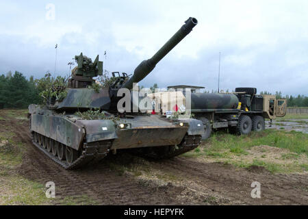 Les soldats de l'Armée américaine affecté à la 3e Bataillon, 69e régiment de blindés, 1re Brigade blindée, l'équipe de combat de la 3ème Division d'infanterie, ravitailler un M1A2 Abrams tank à la gamme pour un exercice de tir réel en Adazi, la Lettonie le 22 août 2016. Les soldats du 3e Bataillon, 69e bras. Rgmt. sont la formation avec leurs alliés baltes à l'appui de l'opération Atlantic résoudre, un effort dirigé par les États-Unis d'être menées en Europe de l'est pour démontrer l'engagement des États-Unis à la sécurité collective de l'OTAN et son dévouement à la paix durable et la stabilité dans la région. Le letton et les soldats américains d'établir des relations grâce à la formation Banque D'Images