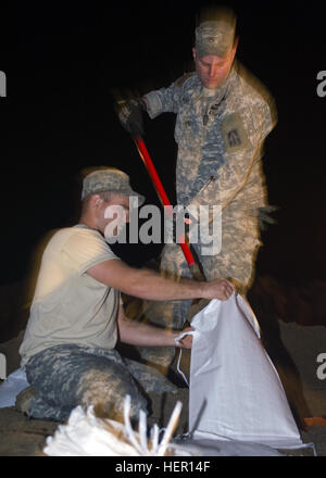 Indiana Army National Guard de la CPS. Matthieu Iacobucci de Martinsville, Indiana, et le sergent. Chris Kindred de Greenwood, Ind., tant dans la société B fantassin, 1er Bataillon, 151e Régiment d'infanterie basé à Martinsville, travailler à travers la nuit du remplissage des sacs à la direction générale des transports du Ministère de l'Indiana à Vincennes, Ind., mardi 26 avril 2011 au cours de la Garde nationale en réponse à des inondations dans la région. Les soldats d'autres travailler six heures par jour, 24 heures sur 24, à remplir une commande de 100 000 sacs de sable au cours des prochains jours nécessaire pour les inondations dans la région. Environ 250 soldats wer Banque D'Images