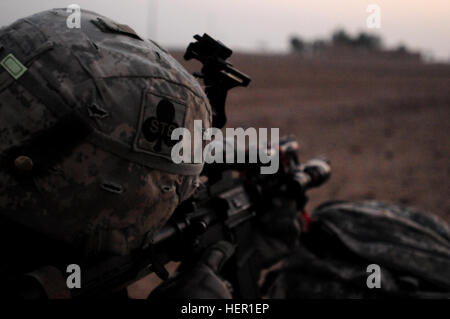 Un soldat de la Compagnie Bravo, 1er Bataillon des troupes spéciales, 1e Brigade Combat Team, la 101e Division aéroportée, tire sur la sécurité sur un petit groupe de maisons au cours de l'opération Syme, le 28 octobre 2008. Syme opération était une opération air assault ciblant les combattants insurgés dans les régions désertiques à l'ouest de Tikrit. Syme 125520 Opération Banque D'Images