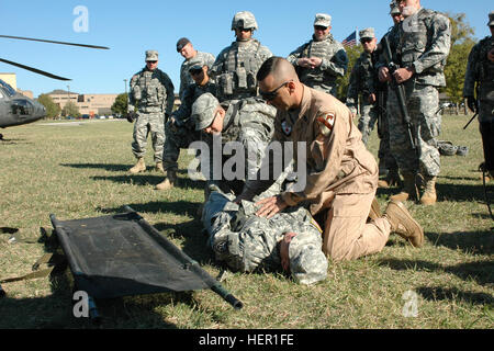 1er Sgt. David Falk (droite), originaire de Fresno, Californie et le sous-officier supérieur pour l'entreprise C, 2e Bataillon, 227e Régiment d'aviation, 1st Air Cavalry Brigade, Division de cavalerie, démontre comment rouler un patient sur une civière avec l'aide de Sgt. Ethan Koontz (gauche) de Madison, Wisconsin (Etats-Unis), et de la CPS. Kenneth Parcs Nationaux (au sol) de Lecanto, en Floride, qui sont à la fois l'intelligence humaine pour collectionneurs Co. B, 303e bataillon de renseignement militaire. La manifestation a été une petite partie d'une classe plus importante sur les vols MEDEVAC enseignés par Falk à l'ouest de Fort Hood, au Texas, le 28 octobre 2008. 1 L'évacuation médicale Banque D'Images