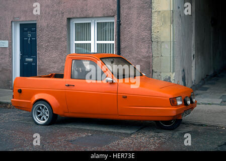 Une orange Robin Reliant pickup garé dans la rue. Banque D'Images