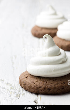 Les cookies au chocolat chaud avec de la guimauve meringue sur fond rustique blanc Banque D'Images
