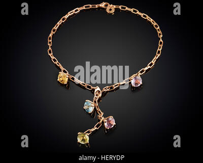 Collier doré avec gemstone isolé sur fond noir. Banque D'Images