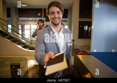 Families sur sa carte d'embarquement au comptoir dans airport terminal Banque D'Images