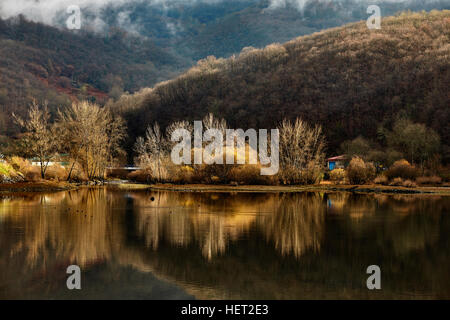 Arbres et montagnes reflété dans l'eau du réservoir du village appelé Rioseco dans le nord de l'Espagne Banque D'Images