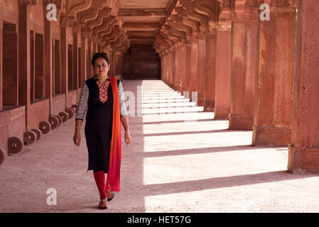 Young woman walking in passerelle colonnade Banque D'Images