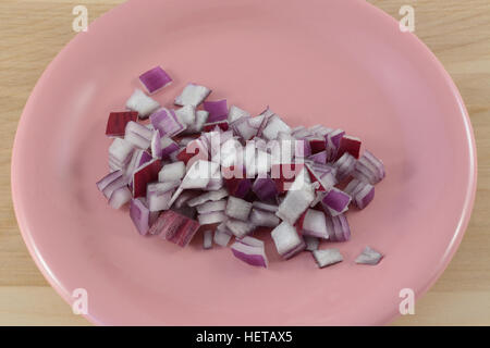 Oignon rouge haché tranches sur la plaque de table en bois de rose Banque D'Images