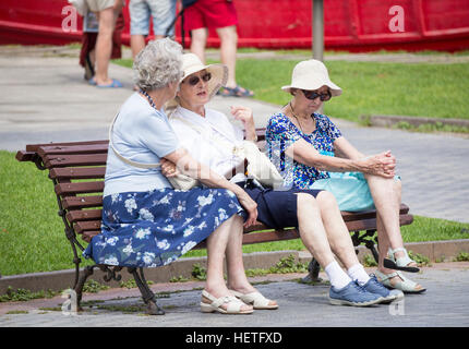 Trois personnes âgées femmes britanniques assis sur un banc en Espagne Banque D'Images